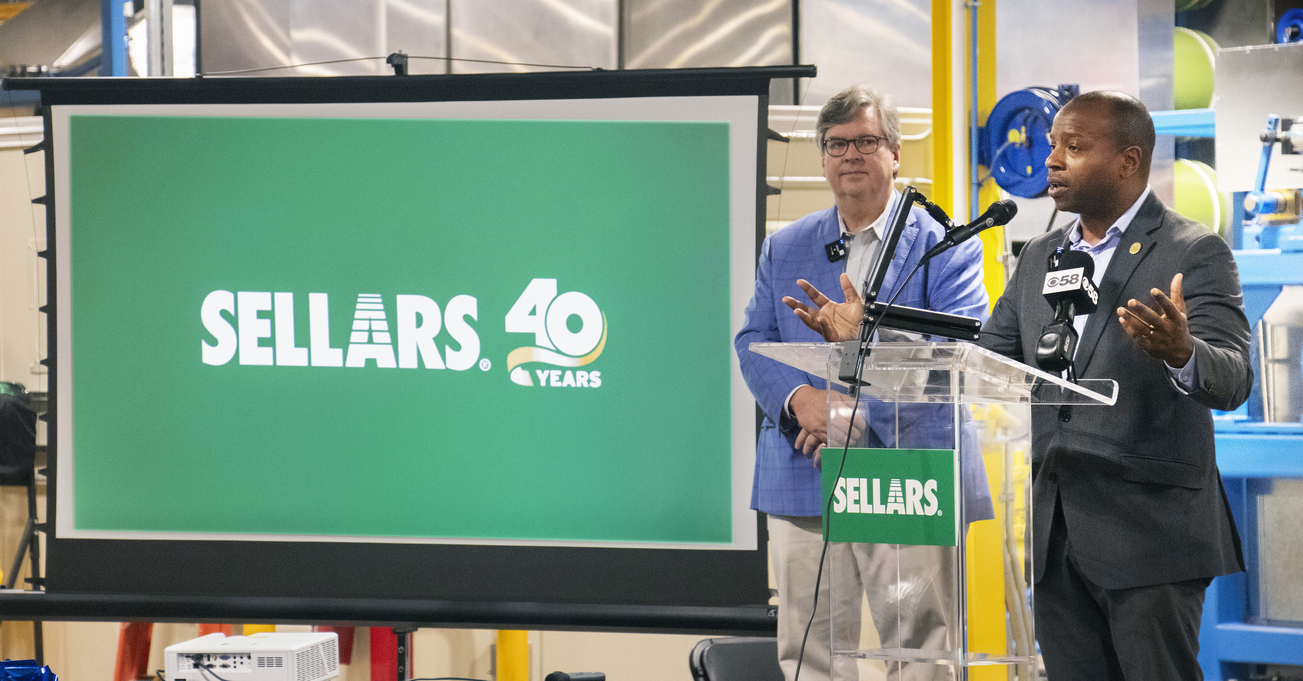 Mayor Johnson and Sellars CEO Tom Sellars speaking on stage about Sellars' growth and community impact of opening new manufacturing facility.